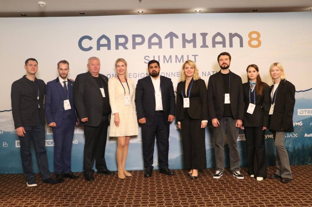Учасники міжнародного саміту за столом переговорів з прапорами держав