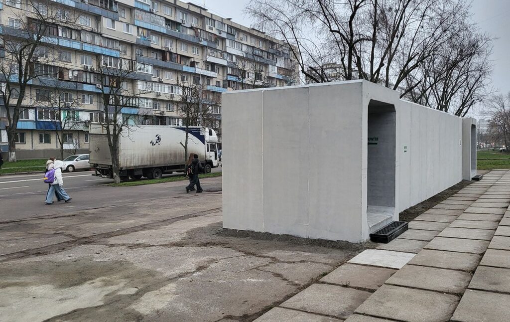 Міська зупинка громадського транспорту поруч із бетонним мобільним укриттям